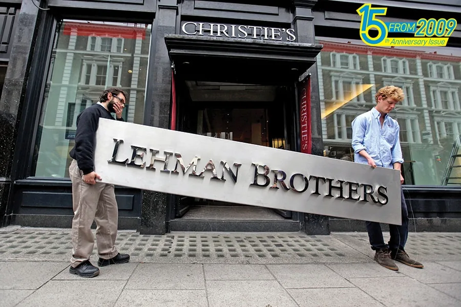 Two people carrying a Lehman Brothers sign out of a Christie's auction house