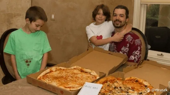 Laszlo Hanyecz and his children at a table with the two pizzas bought for 10,000 bitcoins